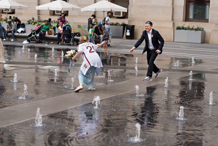 A wedding couple play in the fountain at Dilworth Park in Philadelphia.